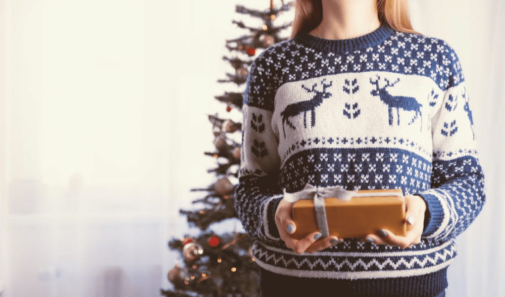 un photo d'une madame qui tien un cadeau dans un sweat islande