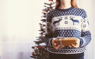 un photo d'une madame qui tien un cadeau dans un sweat islande