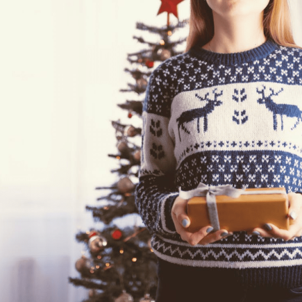 un photo d'une madame qui tien un cadeau dans un sweat islande