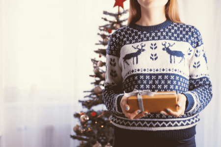 un photo d'une madame qui tien un cadeau dans un sweat islande